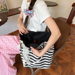 Detail of striped canvas tote bag with elegant white lace trim and spacious interior