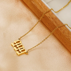 Detail of 18K gold-plated 1999 number necklace on a premium silk-lined wooden tray
