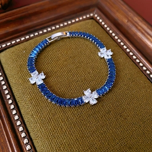 Retro zircon flower bracelet with blue rectangular crystals on a green velvet pad