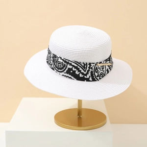 Panama style white straw sun hat with paisley ribbon on a golden display stand