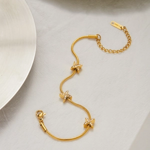 Dettaglio del bracciale a serpente in acciaio dorato 18K con ciondoli a stella con cristalli