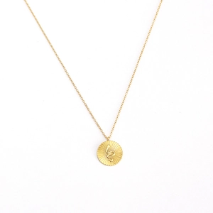 Elegant gold sterling silver necklace with a round snake pendant and sunburst detail