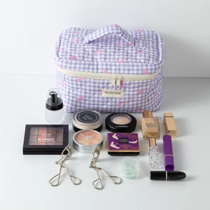 Détail d'une trousse à maquillage violette à carreaux avec nœuds roses et cosmétiques