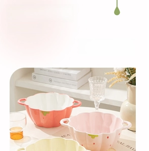Detail of a floral ceramic noodle bowl with strawberry patterns and double handles