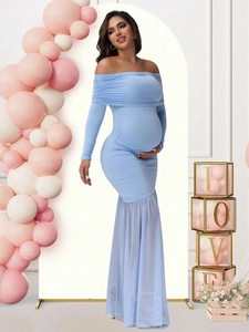 Detail of light blue off-shoulder maternity dress with mesh fishtail hem and long sleeves