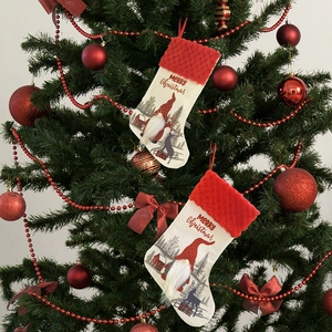 Detail of Christmas stockings with Santa and reindeer motifs hanging on a festive tree