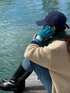 Detalle de guantes de lana azul táctiles con etiqueta tejida usados en exteriores