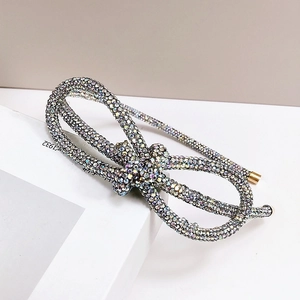 Detailed view of silver bow hairband featuring sparkling multi-colored rhinestones on base