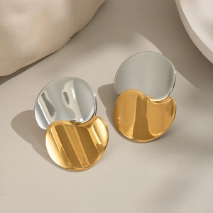 Detail view of two-tone gold and silver geometric circular stud earrings with mirror polish
