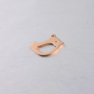 Macro detail of bird-shaped rose gold pendant with smooth mirror-polished finish