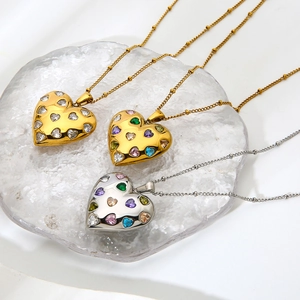 Detailed view of heart pendants with colorful zircons on 18k gold plated beaded necklaces