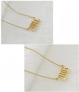 Gros plan d'un collier doré en acier inoxydable avec pendentif numéro 2004 ajouré