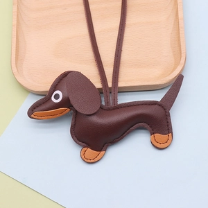Detail of dachshund leather charm featuring contrast stitching and long lanyard strap