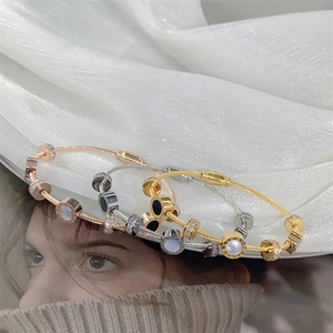 Detail of three-tone stainless steel bangles with roman numerals and shell inlay