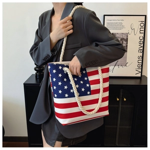 Detail view of large canvas tote bag featuring US flag print and thick cotton rope handles