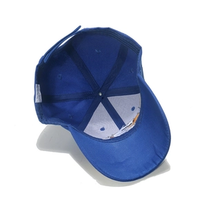 Détail de la casquette bleue montrant le tissu 100% acrylique et l'attache velcro