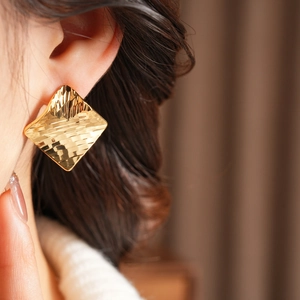 Détail des boucles d'oreilles carrées plaquées or 18 carats avec motif de losange martelé