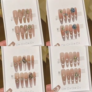 Handmade cat-eye press-on nails with nude pink gradient, glitter, and rhinestone accents