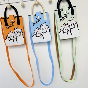 Detailed view of knitted cross-body phone bags in orange, blue, and green with cat motifs