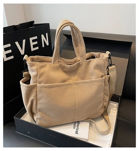 Detail of beige corduroy tote bag with multiple pockets inside a black gift box