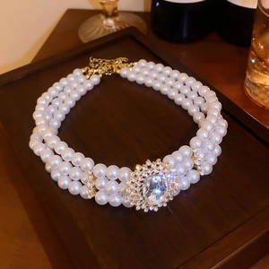 Collier de perles multicouche vintage avec grand pendentif en cristal sur fond de bois sombre