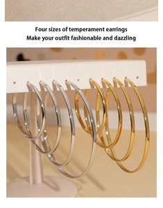 Macro shot of minimalist gold and silver hoop earrings in four sizes with mirror polish
