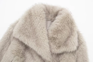 Macro shot of faux fur coat collar showing soft light grey texture and detailed plush fibers