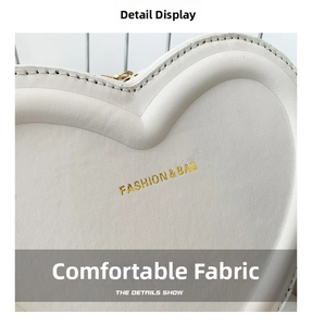 Gros plan sur un sac en cuir blanc en forme de cœur avec texture et logo doré