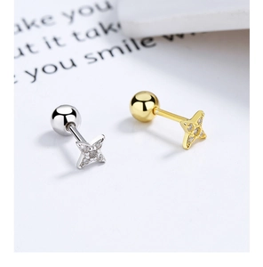 Macro shot of star-shaped 925 silver stud earrings with zirconia in gold and silver finish