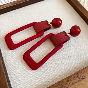 Retro geometric earrings with red resin globes and textured rectangular leather charms