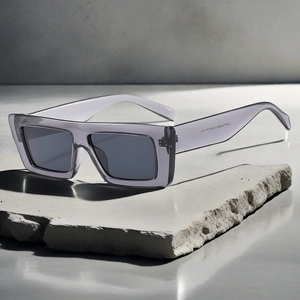 Detail view of gray translucent square sunglasses resting on a natural stone block
