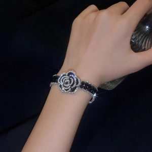 Detail of camellia flower crystal bracelet with sparkling diamonds on a black bead chain