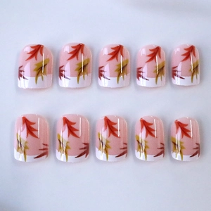 Short square press-on nails with autumn maple leaf design and classic French white tips