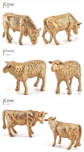 Detailed view of miniature cow and sheep figurines in polished metallic gold finish