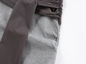Detail view of contrast knit fabric and side drawstring ruching on a maxi skirt