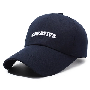 Dark blue baseball cap with white CREATIVE embroidery seen from a 45-degree angle