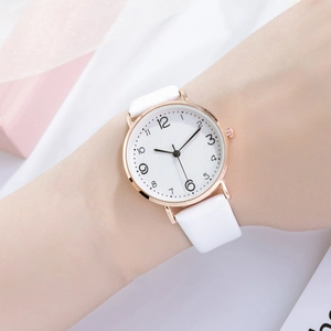 Slim rose gold women's watch with white leather strap and minimalist dial shown on wrist