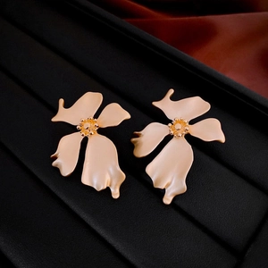 Detailed close-up of French style matte gold flower earrings on a black display tray