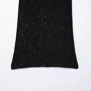Detaillierte Textur von schwarzem Minikleid-Stoff mit bunten Pailletten und Strick