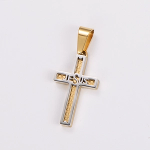 Detail of a two-tone gold and silver cross pendant engraved with JESUS on a white backdrop