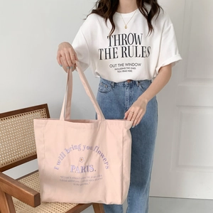 Close-up of pink canvas tote bag with embroidered letters and high capacity handle detail
