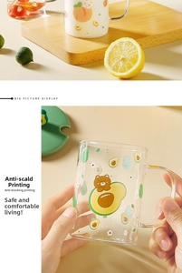 Detail of a clear glass mug with cute cartoon prints and a green lid for stylish home use