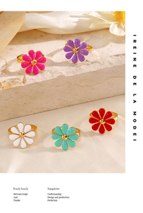 Detail of five colorful daisy rings with gold plating and enamel finish on silk cloth