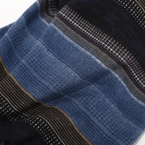 Detailed view of the multi-textured ribbed knit fabric in navy, blue, and brown stripes