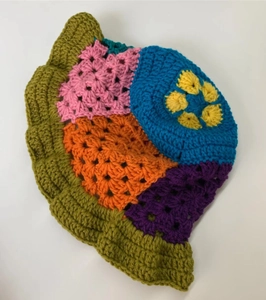 Top view of handmade crochet bucket hat with colorful floral knit pattern and wavy brim