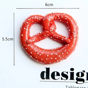 Detail view of 6cm resin pretzel magnet accessory with realistic texture on white background