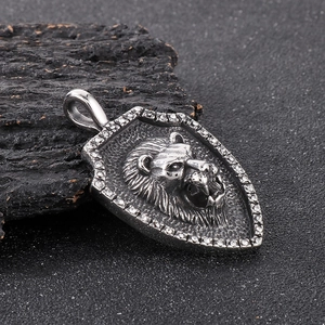 Macro shot of silver shield pendant with embossed lion head and sparkling rhinestones