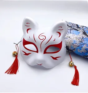 Detail of white Japanese Kitsune mask with red hand-painted patterns and silk tassels