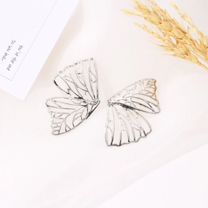 Minimalist silver hollow butterfly wing stud earrings on white silk with wheat decor