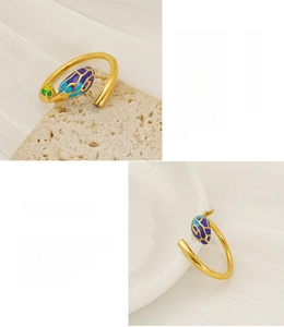 Detailed macro view of an 18K gold plated leaf ring with purple enamel and open band